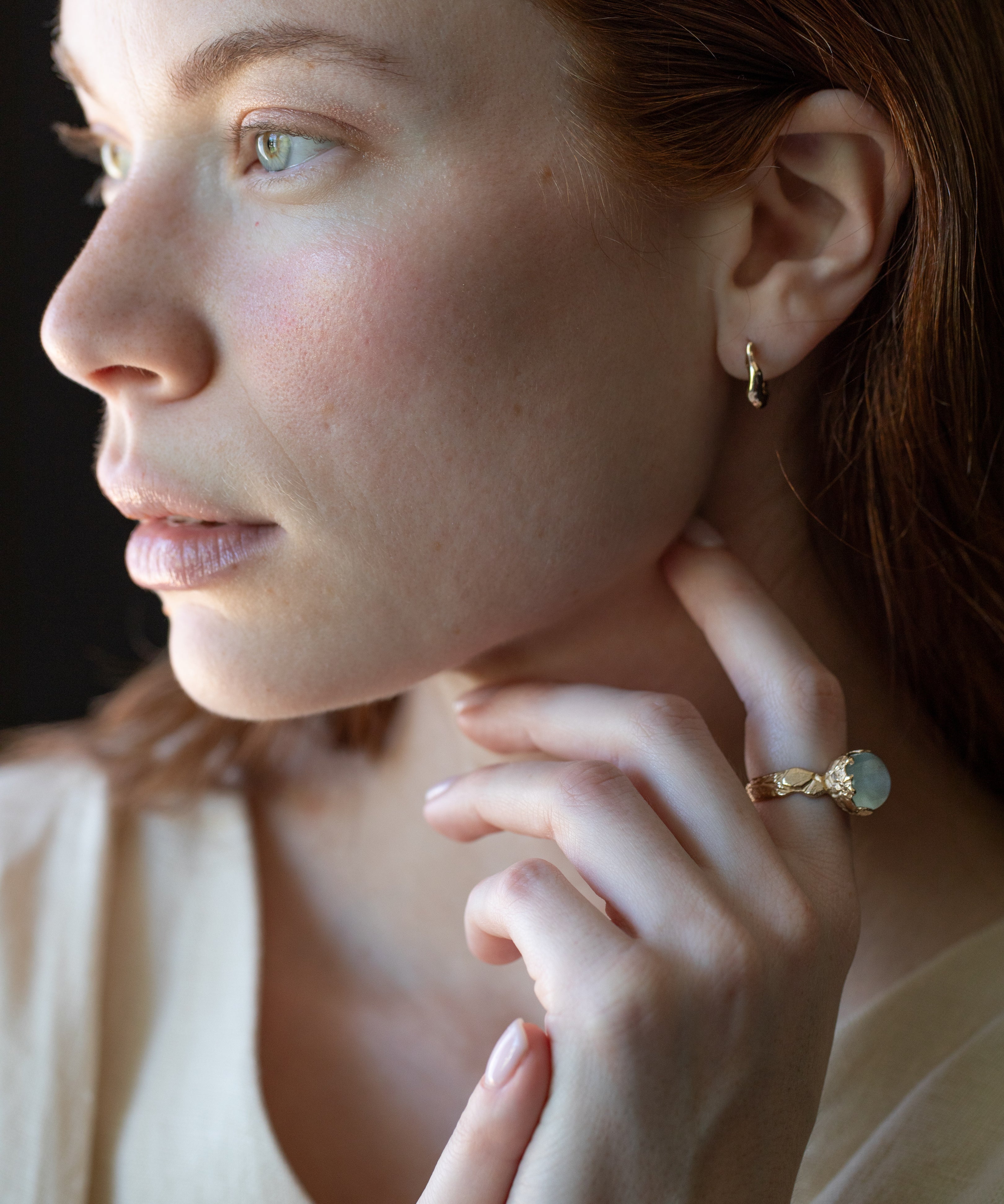 Close-up of hand-carved huggie hoops with champagne diamonds